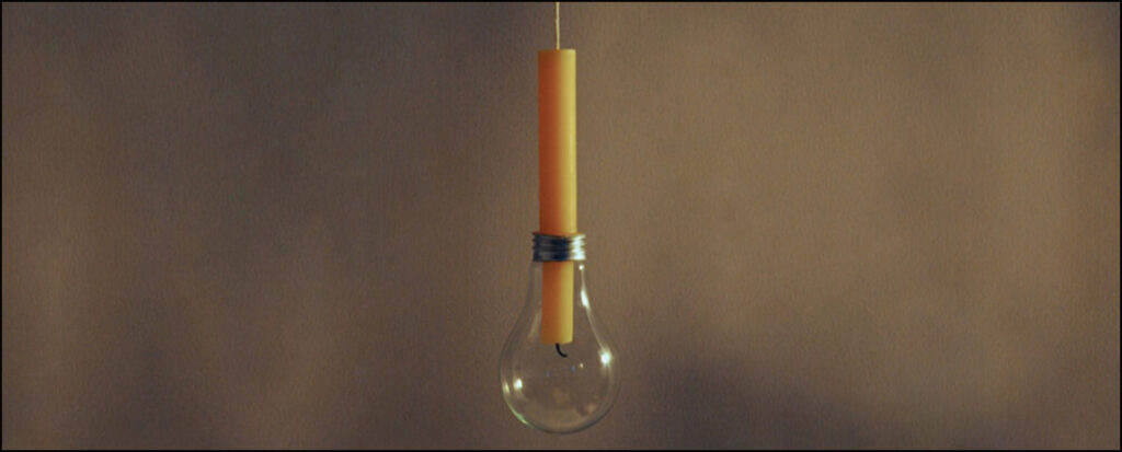 sculpture of altered light bulb with candle