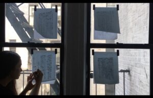 video still of Manon tracing writing on a window